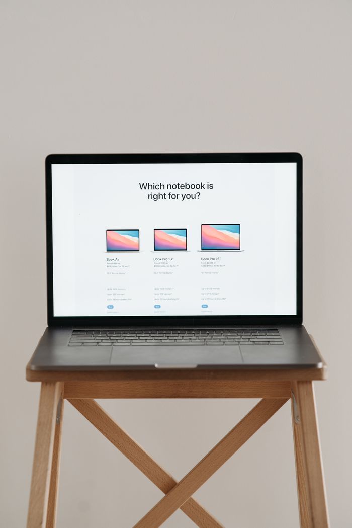 Laptop on a wooden stand with screen showing notebook comparison.
